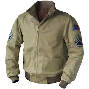 Puede incluir: Chaqueta de estilo militar caqui con cremallera frontal, dos bolsillos delanteros y cuello y puños marrones. Parches con insignias militares cosidos en las mangas. La chaqueta tiene un diseño clásico de chaqueta bomber.
