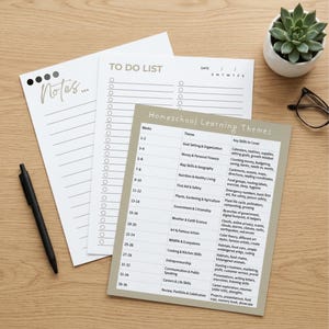 May include: Three printed paper sheets featuring a Notes page with bullet points, a To Do List with checkboxes, and a Homeschool Learning Themes chart with a 36-week curriculum schedule. A black pen is positioned next to the white and beige stationery.