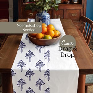 May include: A white table runner with a repeating navy blue floral pattern. A wooden bowl filled with oranges and limes sits on the runner. A blue and white vase and the text "No Photoshop Needed" and "Canva Drag & Drop" are also visible.