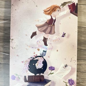 May include: Illustration of a young girl reaching for a book, with a bubbling cauldron, books, and floating objects. The artwork features a soft color palette with purple and pink accents, and the text "Colorful Corner LLC".