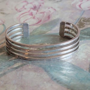 May include: A silver bracelet with five bands. The bracelet is marked "Mexico 925" and "T.H.15".