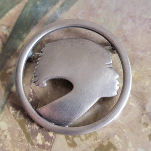 Broche vintage de peltre con perfil de mujer