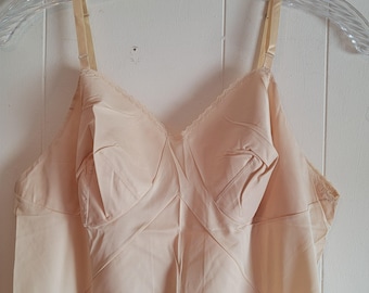 May include: A pale pink vintage slip with adjustable straps and a lace trim. The slip has a fitted bodice and a flowing skirt.