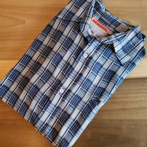 May include: A blue and white plaid button-down shirt with a label that reads "South Pacific Mills" and "Size 16 1/2 - 34".