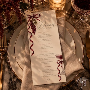 Op de afbeelding: Een verticale menukaart met een bordeauxrood lint en een druivenillustratie bovenaan en een wijnglasafbeelding onderaan. De tekst luidt Dinner Menu, First Course, Second Course, Main Course en Dessert met diverse gerechten op de kaart.
