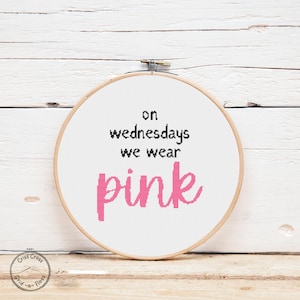 Puede incluir: Un aro de bordado blanco con el texto "on wednesdays we wear pink" en letras negras y rosas.