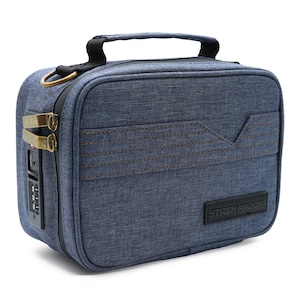 Pode incluir: Uma bolsa azul em estilo ganga com uma pega preta e um anel dourado. A bolsa possui uma fechadura de combinação e fechos dourados. As palavras "STASH PROOF" estão impressas numa etiqueta preta na frente da bolsa.