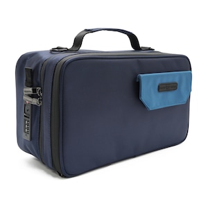 Può includere: Una borsa da viaggio blu navy con manico nero e lucchetto a combinazione. La borsa ha una piccola tasca blu sul davanti. La borsa è rettangolare e sembra essere realizzata in un materiale resistente.