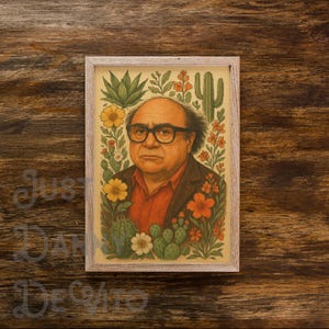 Könnte beinhalten: Gerahmter Kunstdruck mit einem Porträt von Danny DeVito, umgeben von bunten Blumen und Kakteen. Das Kunstwerk hat eine Vintage-Ästhetik mit einem hellen Holzrahmen, ideal, um jedem Raum eine persönliche Note zu verleihen.