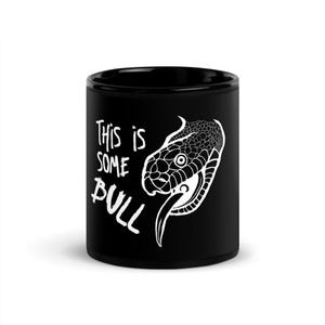 Könnte beinhalten: Schwarze Keramik-Tasse mit dem weißen Schriftzug "This is Some Bull" und einer weißen Illustration eines Schlangenkopfes. Die zylindrische Tasse ist für heiße oder kalte Getränke geeignet.