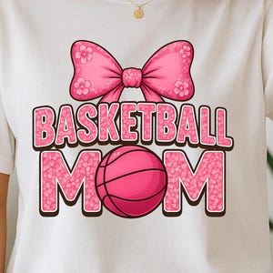 Basketball Mom PNG mit rosa Schleife und floralem Briefdesign mit femininer Basketball-Grafik für niedliche sportliche DIY-Shirtgeschenke
