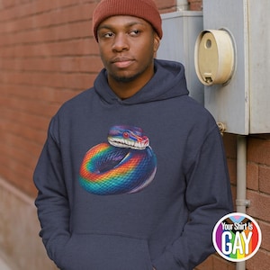 Könnte beinhalten: Marineblauer Kapuzenpullover mit einem farbenfrohen Regenbogen-Schlangen-Motiv. Die Schlange hat rote Augen und ein detailliertes Design. Der Hoodie hat eine Kapuze mit Kordelzug und eine Kängurutasche. Der Text "Your Shirt Is GAY" befindet sich unten rechts.