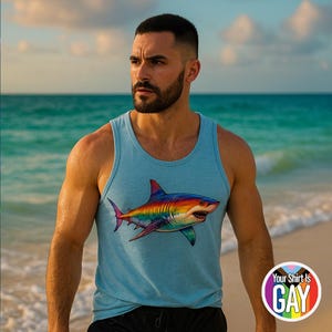 May include: Pale blue vest top with a vibrant rainbow shark design. The top has a round neck and is made from a soft, breathable fabric. The text "Your Shirt Is GAY" is printed on a circular sticker.