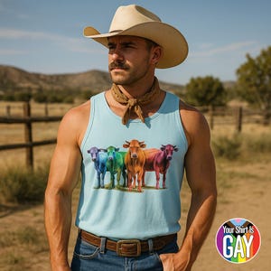 May include: A light blue vest top with a graphic of four colourful cows: purple, green, orange, and red. The vest top is worn by a person wearing a cowboy hat and a brown neckerchief. The image includes the text "Your Shirt Is GAY".