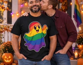 Könnte beinhalten: Ein schwarzes T-Shirt mit einer Grafik eines lächelnden Geistes in horizontalen Regenbogenstreifen. Der Geist hat große schwarze Augen und einen breiten Mund und ist mittig auf der Brust platziert. Das Motiv ist in leuchtenden Farben gedruckt.