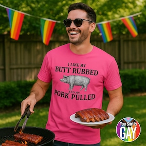 Op de afbeelding: Een persoon draagt een felroze t-shirt met de tekst "I like my butt rubbed and my pork pulled" en een tekening van een varken. De persoon houdt een bord met gekookte ribben en een tang vast.