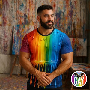 May include: A short-sleeved t-shirt with a rainbow dripping paint design. The shirt transitions from red to blue, with yellow and green in between. The shirt has a black collar and the text "Your Shirt Is GAY" on a circular graphic.