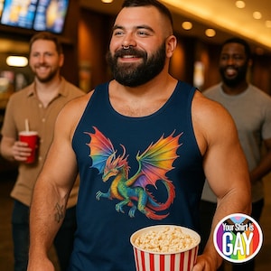 May include: Navy blue tank top featuring a colorful dragon design with rainbow wings. The dragon is depicted in shades of green, blue, red, and yellow. The tank top is worn by a person holding a popcorn bucket. The text "Your Shirt Is GAY" is on a circular sticker.