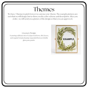 May include: A rectangular gold-toned metal frame containing two glass panes with pressed green ferns, olive leaves, and botanical sprigs arranged in a circular wreath shape. The word EXAMPLE is printed in black in the center of the glass.