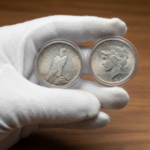 May include: A set of three ceramic mugs with a speckled, matte finish. The mugs are in shades of cream, light gray, and dark gray. Each mug has a simple, minimalist design and a rounded handle.