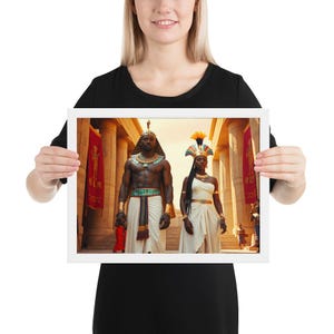 May include: Framed print depicting an ancient Egyptian couple. The man wears a gold headdress and collar, the woman a feathered crown. They stand before columns and red banners, creating a historical scene. The image is framed in white.