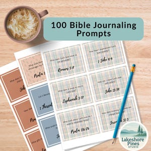 May include: A set of Bible journaling prompts with the text "100 Bible Journaling Prompts." The prompts are on cards with Bible verses and questions. A blue pencil and a cup of coffee are also in the image.