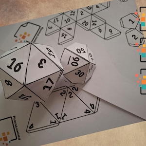 May include: White paper dice with black numbers, including a 20-sided die and a 10-sided die, are displayed on a light gray surface. The image also shows unfolded die templates and icons for PDF, SVG, and PNG file formats.