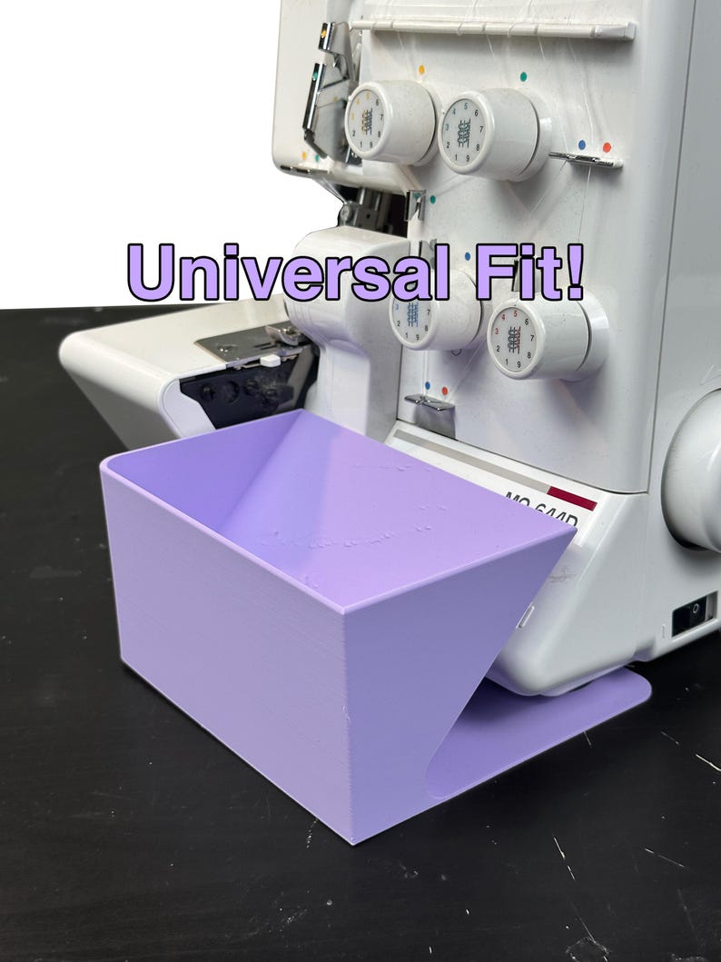 Może przedstawiać: Jasnofioletowy pojemnik na odpady do maszyny do szycia z napisem "Universal Fit!" umieszczony przed biało-szarą owerloką. Pojemnik jest prostokątny z rozszerzonym otworem. Owerlok posiada wiele szpulek z nićmi.