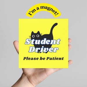 Peut inclure: Un aimant carré jaune avec une silhouette de chat noir et l'inscription "Student Driver Please be Patient" en bleu et blanc. Un aimant en arc jaune au-dessus indique "I'm a magnet!"