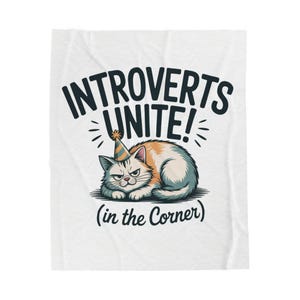 May include: White blanket with a cartoon cat wearing a party hat. The text "INTROVERTS UNITE!" is above the cat, and "(in the Corner)" is below. The cat has orange, white, and blue fur and a grumpy expression.