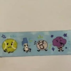 Peut inclure: Ruban bleu clair orné de personnages de dessins animés. On y trouve une balle de tennis triste, un marqueur, un stylo, une balle avec un visage en colère, un cerveau violet, un carré vert et un beignet. Le ruban a un fond bleu clair.