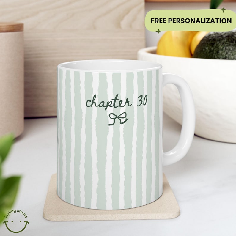 May include: White ceramic mug with a green and white striped pattern. The mug features the text "chapter 30" with a bow graphic. The mug is on a beige coaster. The words "FREE PERSONALIZATION" are in the background.