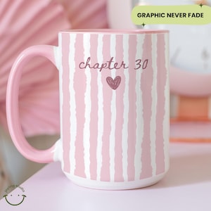 May include: A large pink and white striped ceramic mug with a pink handle and interior. The mug features the text "chapter 30" with a heart graphic. The words "Graphic Never Fade" are in a green rectangle.