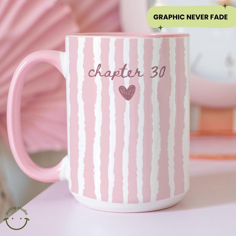 May include: A large pink and white striped ceramic mug with a pink handle and interior. The mug features the text "chapter 30" with a heart graphic. The words "Graphic Never Fade" are in a green rectangle.