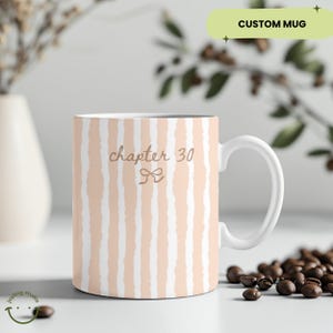 May include: White ceramic mug with a peach and white striped pattern. The mug has a white handle and the text "chapter 30" with a bow graphic. The words "CUSTOM MUG" are in a green rectangle.
