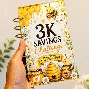 Puede incluir: Un rastreador de ahorros rectangular con anillas metálicas doradas, con un diseño en amarillo y blanco que incluye ilustraciones de abejas, panales, una colmena y tarros de miel. El texto dice 3K SAVINGS Challenge y SMALL SAVINGS, BIG POSSIBILITIES.
