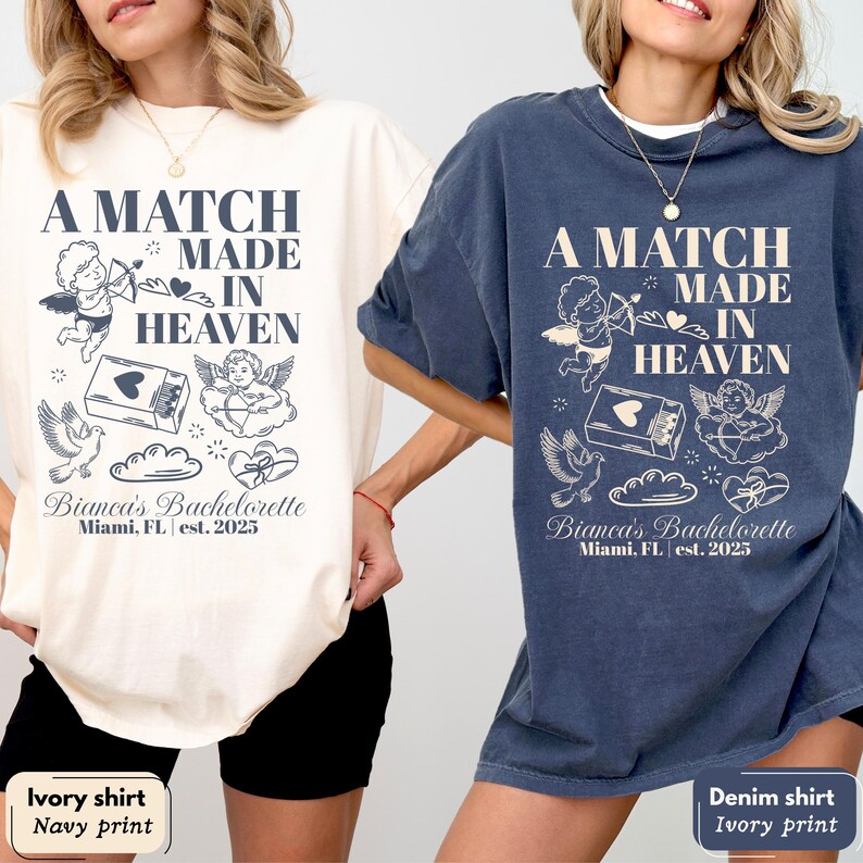 以下が含まれることがあります： アイボリーとデニムの2枚のオーバーサイズTシャツ。どちらもネイビーのプリントです。「A MATCH MADE IN HEAVEN」の文字、天使、鳩、ハートのデザイン。また、「Bianca's Bachelorette Miami, FL est. 2025」の文字もプリントされています。