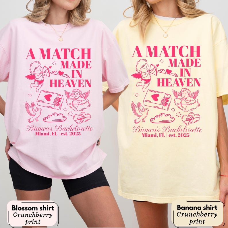 以下が含まれることがあります： ピンクと黄色の2枚のTシャツ。ピンク色の「A MATCH MADE IN HEAVEN」の文字。シャツには、天使、鳩、ハートのピンク色のグラフィックも描かれています。「Bianca's Bachelorette Miami, FL est. 2025」の文字が下に印刷されています。