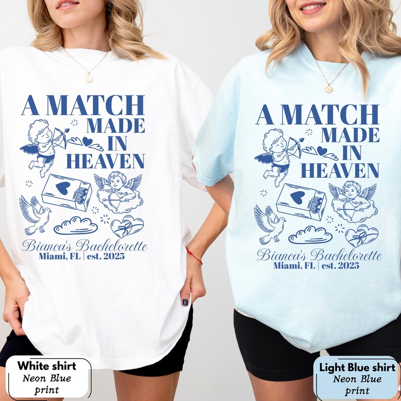 以下が含まれることがあります： 白と水色の2枚のTシャツ。それぞれにネオンブルーのグラフィックが施されています。グラフィックには、天使、ハート、そして「Bianca's Bachelorette, Miami, FL est. 2025」の文字とともに「A Match Made in Heaven」と書かれています。