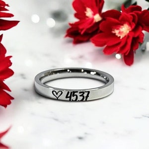 May include: A silver ring with a heart and the number 4537 engraved on it.