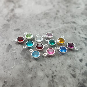 Puede incluir: Surtido de 15 peque&ntilde;os abalorios redondos de vidrio con engastes plateados. Los abalorios son de varios colores, incluyendo rojo, azul, verde, rosa y transparente.