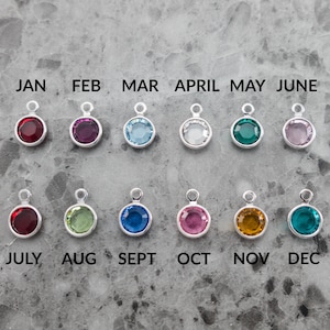 Puede incluir: Doce abalorios plateados con cristales de colores que representan los meses del a&ntilde;o. Enero es rojo, febrero es morado, marzo es azul claro, abril es transparente, mayo es verde, junio es rosa, julio es rojo, agosto es verde, septiembre es azul, octubre es rosa, noviembre es naranja y diciembre es verde azulado.