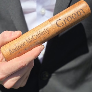 Könnte beinhalten: Ein Stiftetui aus Holz mit dem eingravierten Wort "Groom". Das Etui trägt auch den Namen "Andrew McCafferty" und das Datum "May 31st 2025". Das Stiftetui wird von einer Person in einem Anzug gehalten.