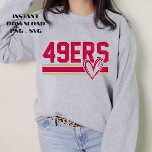 May include: A gray sweatshirt with the text "49ERS" in red block letters, a red and gold stripe, and a heart-shaped football graphic. The words "INSTANT DOWNLOAD PNG . SVG" are printed in black in the upper left corner.