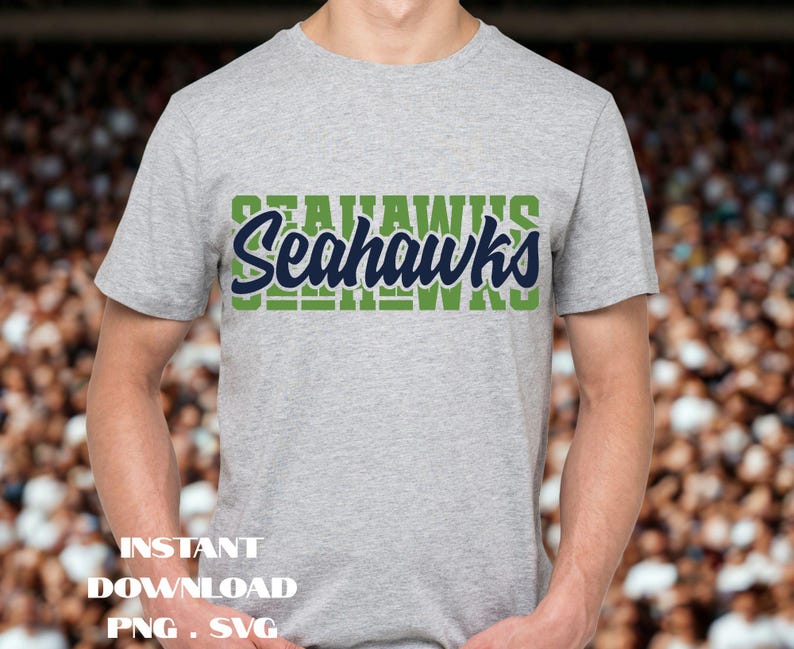Puede incluir: Una camiseta gris con la palabra "Seahawks" en un dise&ntilde;o verde y azul marino en el pecho. El texto "Instant Download PNG SVG" est&aacute; en la parte inferior de la imagen.