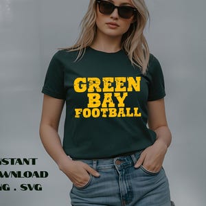 May include: Dark green t-shirt with the text "GREEN BAY FOOTBALL" in distressed yellow lettering. The shirt is a classic crew neck style. The words "INSTANT DOWNLOAD PNG . SVG" are printed below the shirt.