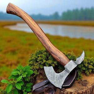 May include: A handcrafted axe with a curved wooden handle and a patterned steel blade. The axe is resting on a tree stump with a leather sheath. The handle is a dark brown color, and the blade has a unique, swirling pattern.