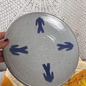 Handgemachte 1990er Studiokeramik Untertasse – gesprenkelte graue Glasur mit blauer Figur – signiert und Unikat