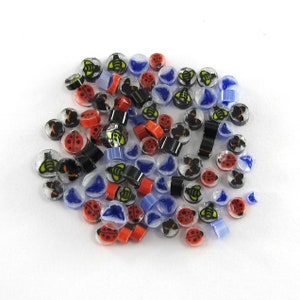 May include: Assortment of colorful glass beads with various insect and flower designs. The beads are translucent and feature a mix of red, blue, yellow, and black colors.