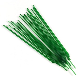 Puede incluir: Un conjunto de alambres florales verdes, finos y rectos, dispuestos sobre un fondo blanco. Los alambres son de un tono verde vibrante y parecen estar hechos de un material flexible. Probablemente se utilizan para manualidades o arreglos florales.